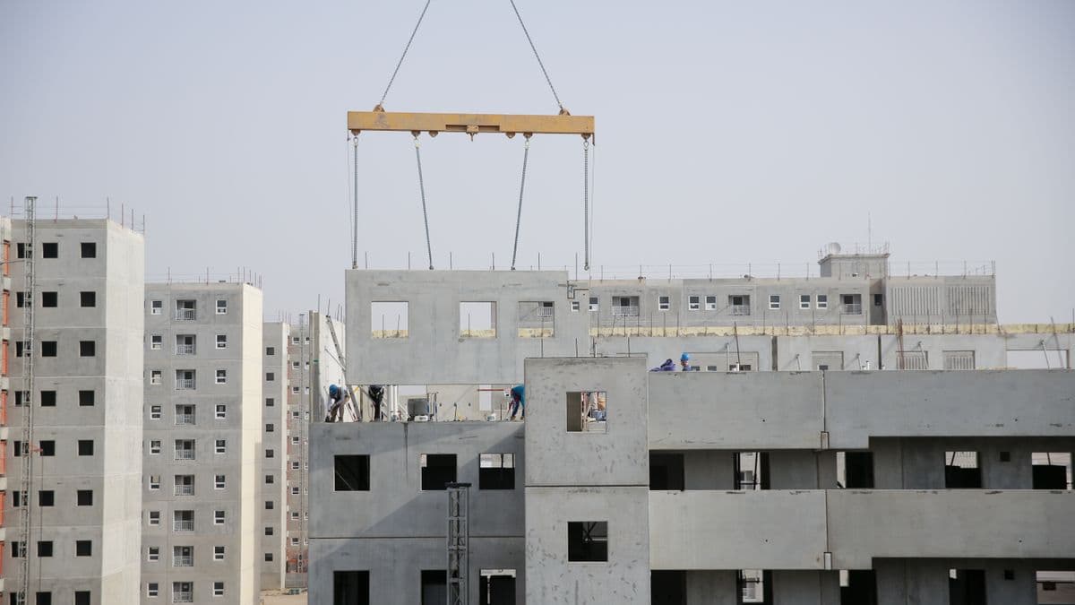 Overhead crane lifting a precast concrete panel